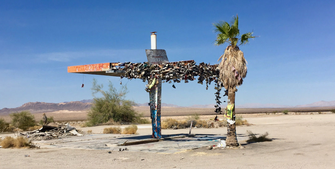 Shoes handing from a deserted gas station in the desert